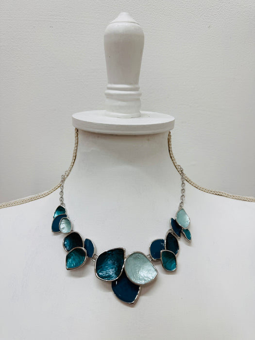 Turquoise enamel leaf statement necklace with silver-tone chain and layered leaf shaped accents, displayed on a mannequin.