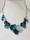 Turquoise enamel leaf statement necklace with silver-tone chain and layered leaf-shaped accents, displayed on a mannequin.