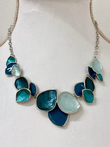 Turquoise enamel leaf statement necklace with silver-tone chain and layered leaf-shaped accents, displayed on a mannequin.