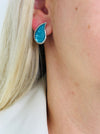 Turquoise teardrop enamel stud earrings with silver tone finish, displayed on a model.