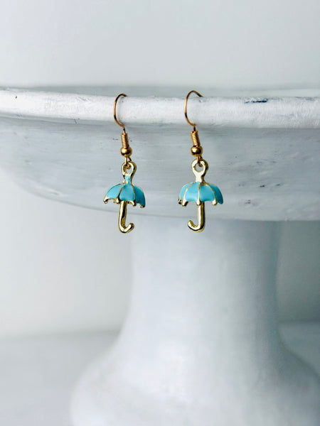 Turquoise umbrella-shaped earrings on a white stand