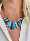 Geometric enamel necklace with layered rectangular pieces in turquoise, grey and gunmetal, on silver-tone chain