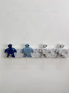 A rustic white-painted wooden wall hook rack featuring four turtle-shaped hooks in dark blue, light blue, and distressed white, mounted on a white wall.