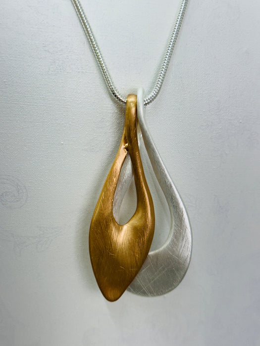 close-up of gold and silver pendant on a chain