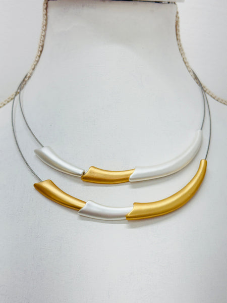 close-up of necklace with gold and silver curved design 