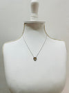 Necklace with a heart-shaped pendant on a mannequin bust against a plain background