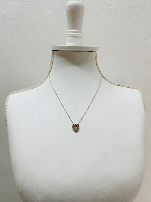 Necklace with a heart-shaped pendant on a mannequin bust against a plain background
