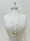 Elegant two - tone intertwined heart pendant necklace on a silver chain displayed on a mannequin