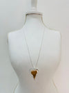 A necklace with a heart-shaped pendant displayed on a mannequin bust.