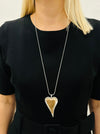 Stylish two - tone long heart pendant necklace on a silver chain displayed on a model