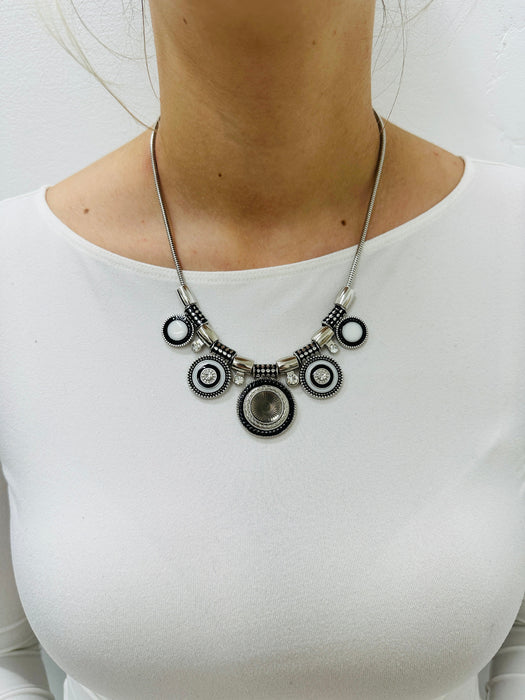 Necklace with circular design worn by a person on a white background