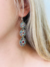 Close-up of a colorful earring worn by a person with blonde hair.