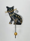 Handmade metal cat hook with antique gold and silver detailing on white background.