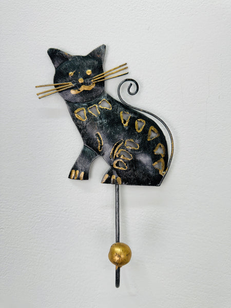 Handmade metal cat hook with antique gold and silver detailing on white background.