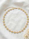 Necklace with daisy flower pendants on a white fabric background