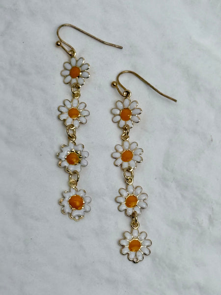 Daisy-shaped earrings on a light gray background