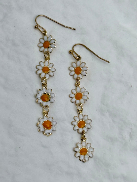 Daisy-shaped earrings on a light gray background