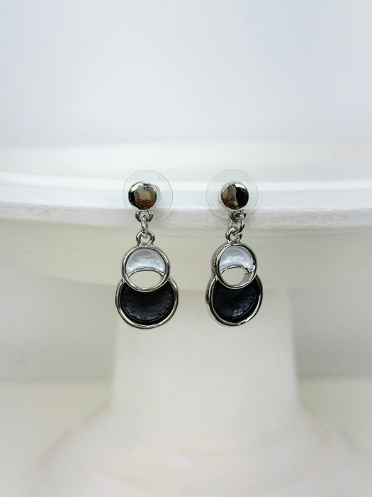 Pair of earrings with black and silver circular designs on a white background