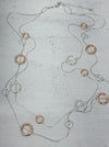 Necklace with circular pendants on a textured surface