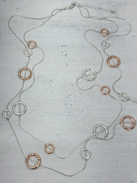 Necklace with circular pendants on a textured surface