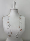 long silver and rose gold necklace with textured circle charms displayed on mannequin