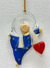Hand-painted blue angel with gold stars and red heart.