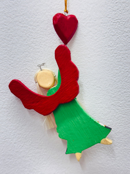 Back view of wooden hanging angel with gold string and red heart.