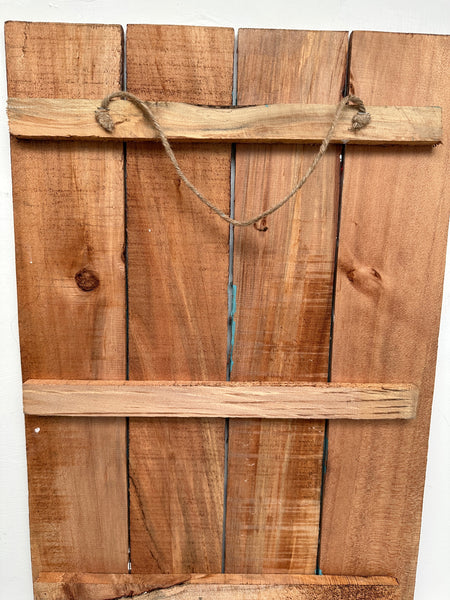 Back of Black Cat wooden sign showing natural wood panels and hanging rope.
