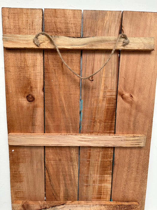 back view of wooden sign with rope attached to back