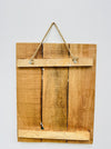 Back of Chat Noir wooden sign showing natural wood panels and hanging rope.