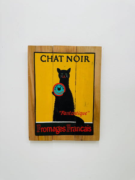 Hand-painted Chat Noir wooden sign with French vintage poster design and hanging rope on white background.