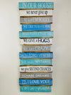 Hand-painted In Our House wooden sign with inspirational phrases and hanging rope on white background.