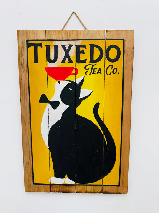 Hand-painted Tuxedo Cat wooden sign with tea cup illustration and hanging rope on white background.