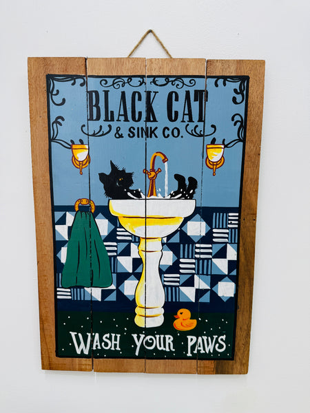 Hand-painted wooden sign with black cat bathroom illustration and hanging rope on white background.