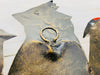close up of the hook on the back of metal birds on a wire
