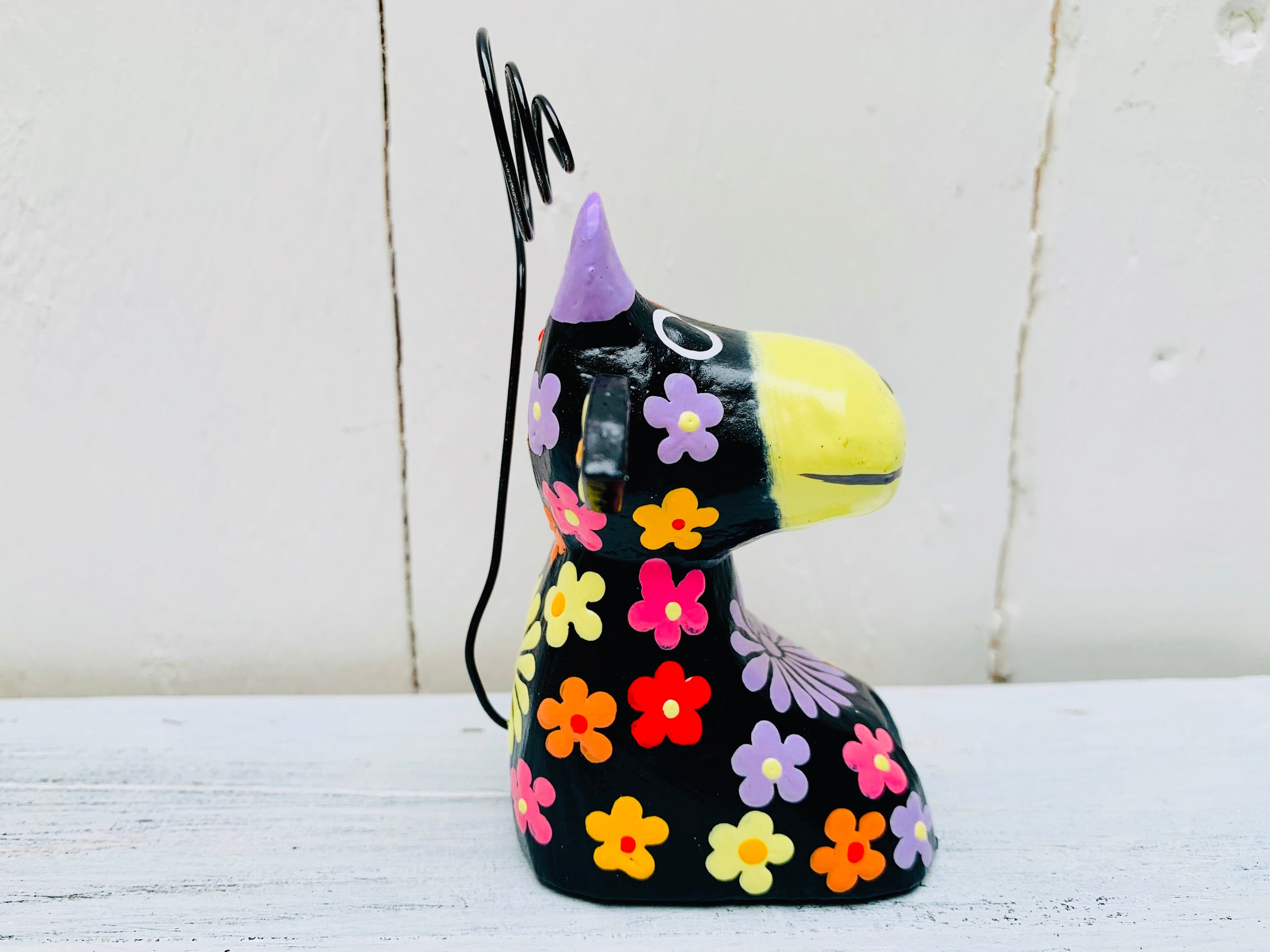 side close up of wooden flower cow in black