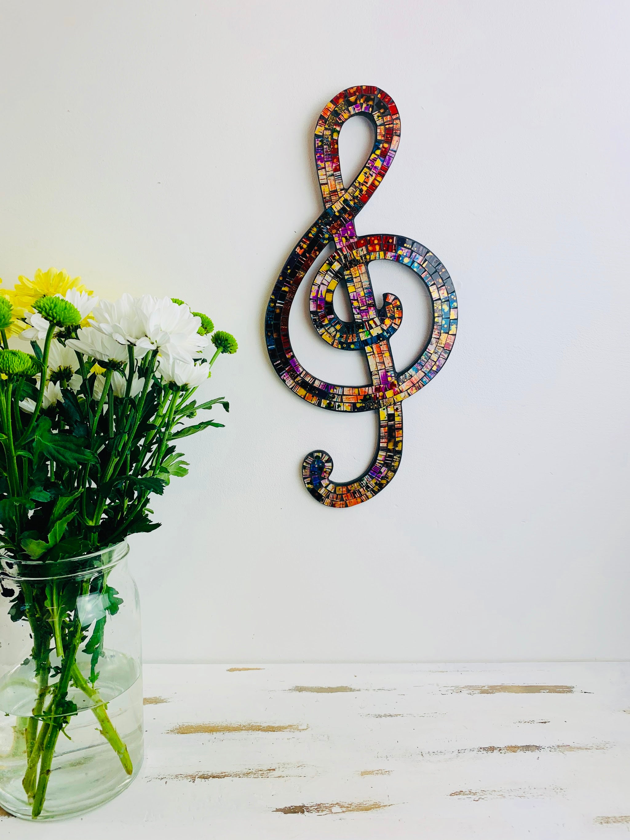 front view of mosaic treble clef hung on wall