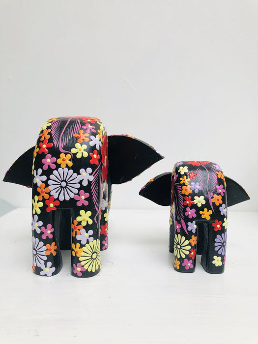back view of small and large wooden flower elephants