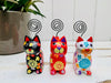 front view of black, white and red sitting flower kitties