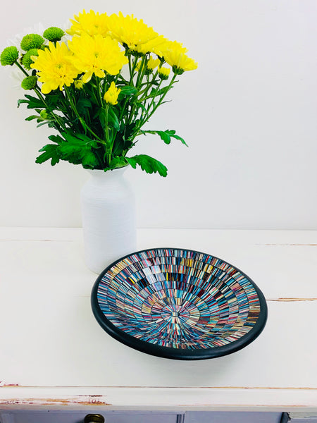 front view of mosaic bowl in blue with flowers as display next to it