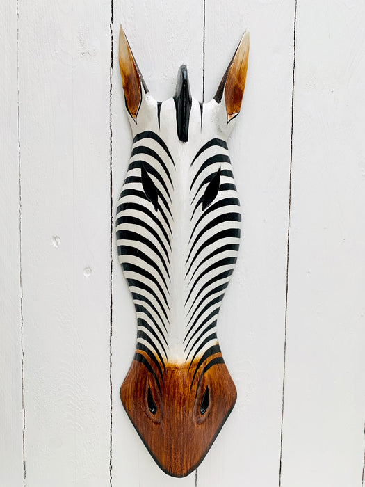 front view of zebra wood mask on white wall