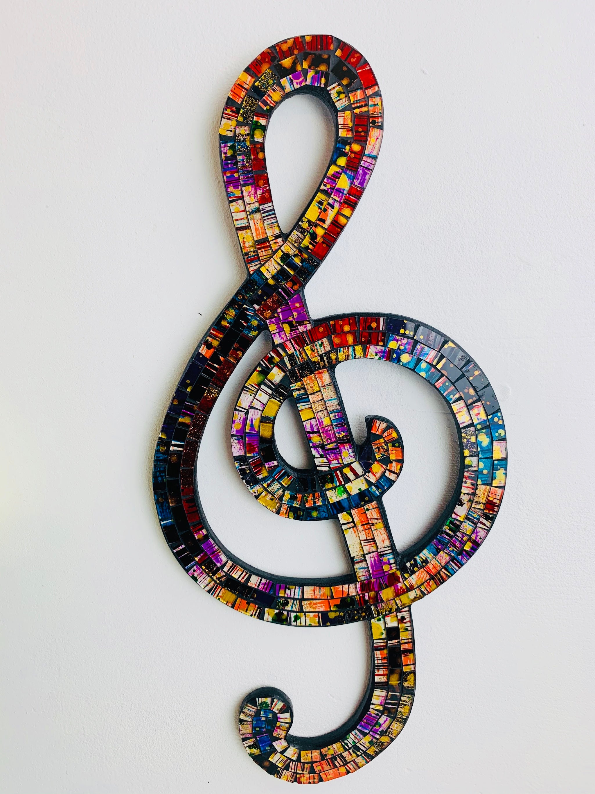 front view of mosaic treble clef on white background