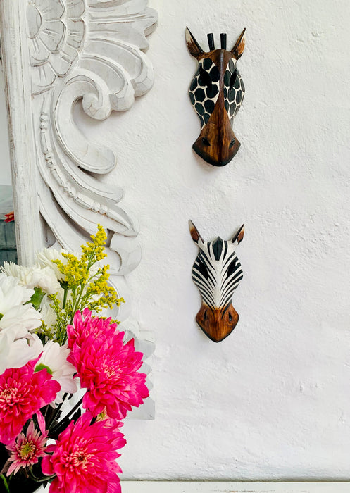 display view of giraffe and zebra wood mask on wall
