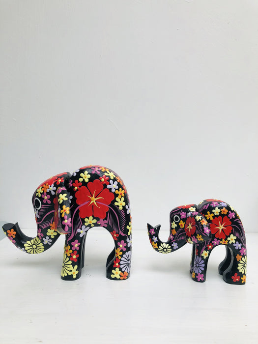 side view of small and large wooden elephants