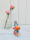 display view of wooden flower cow next to a vase of flowers