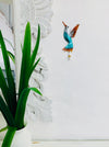 display view of hummingbird hook attached to the wall by a green plant