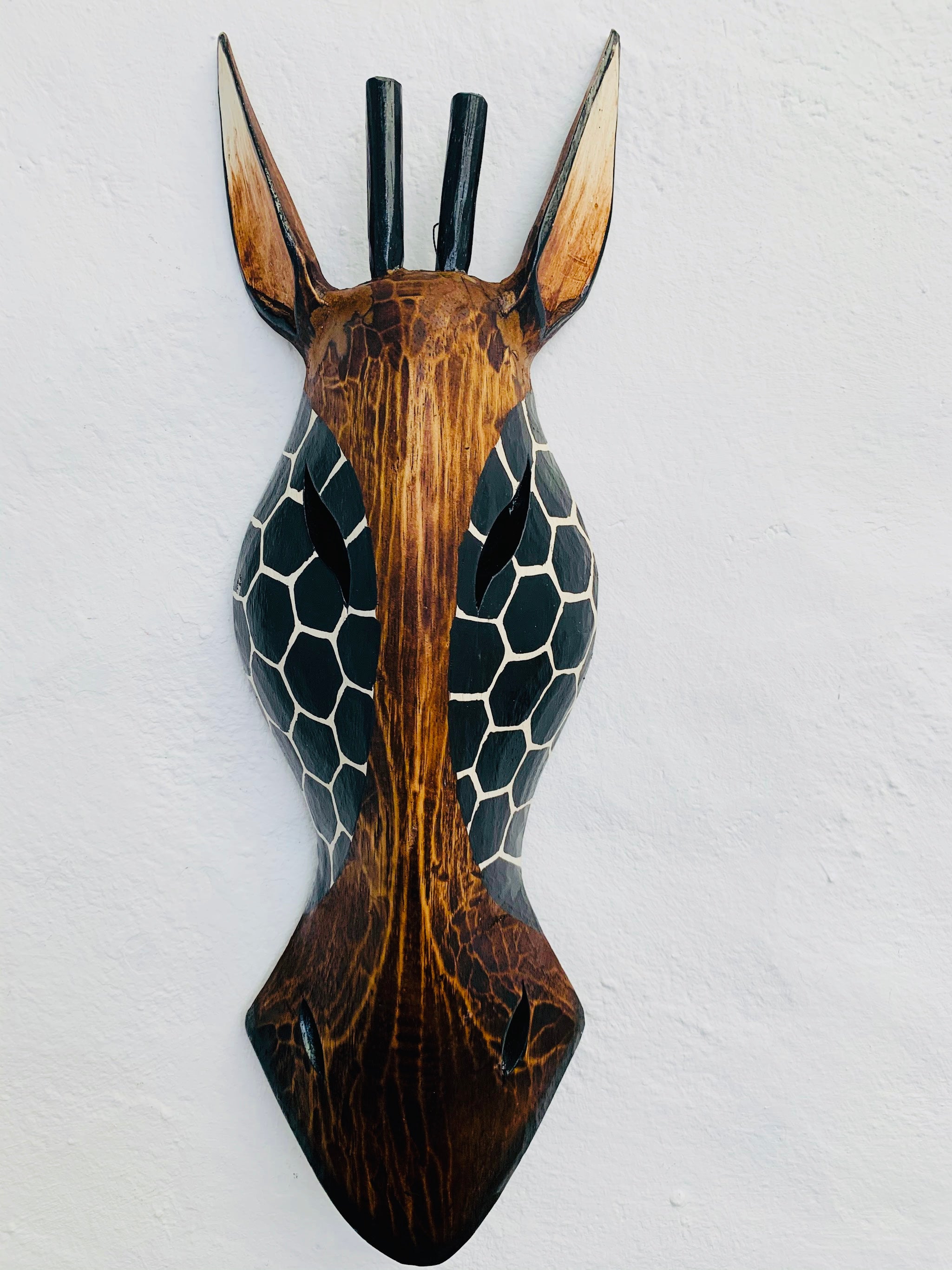 front view of wooden giraffe mask