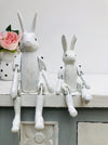 display view of small and large white wooden bunnies sat on white surface