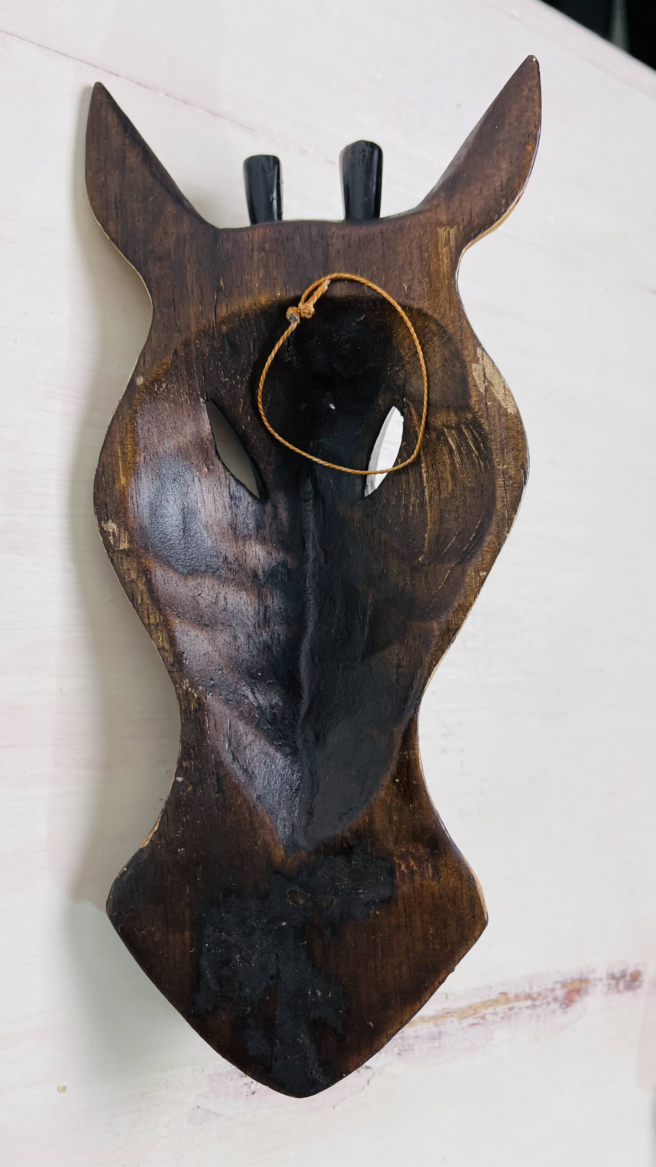 back view of wood mask with hook attached