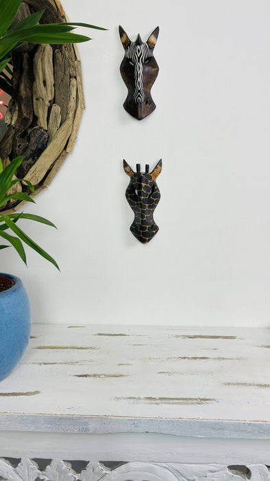 display view of giraffe and zebra wooden masks attached to wall